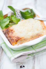 Vegetable lasagna in a glass dish, close-up, vertical shot