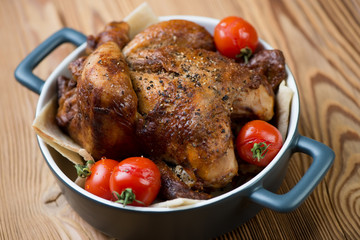 Whole baked spicy chicken with tomatoes, horizontal shot