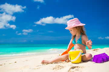 Adorable little girl playing on the beach with white sand