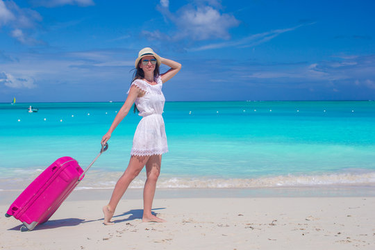 Young beautiful woman walking with her bag on tropical beach