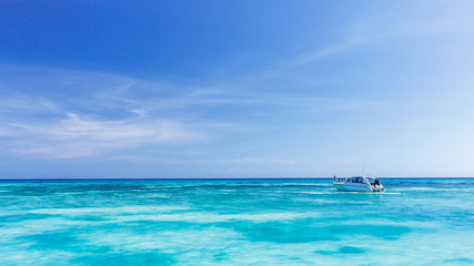 Obraz na płótnie Canvas A tourist speed boat in crystal clear blue sea at tropical islan