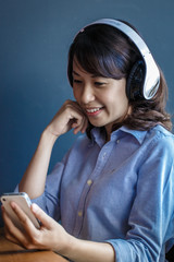 Young woman using smartphone with wireless headphone