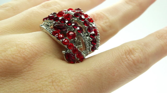 jewelery ring with red ruby crystals putting on the finger