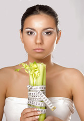 A woman measuring a vegetable with a measure tape
