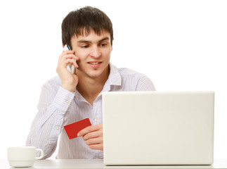 A man with a credit card, talking on the phone