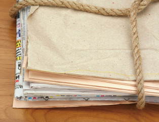 A newspaper stack isolated on wood background.
