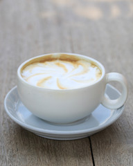 Cappuccino coffee cup on wooden background