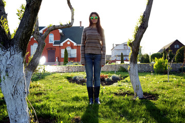 Full-length portrait of a young woman standing in garden