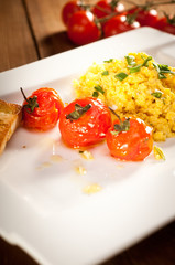 Scrambled eggs with roasted cherry tomatoes, toast and chive