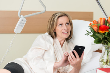 frau im krankenhaus mit ihrem smartphone