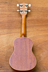 Naklejka premium The ukulele is placed on a wooden floor.