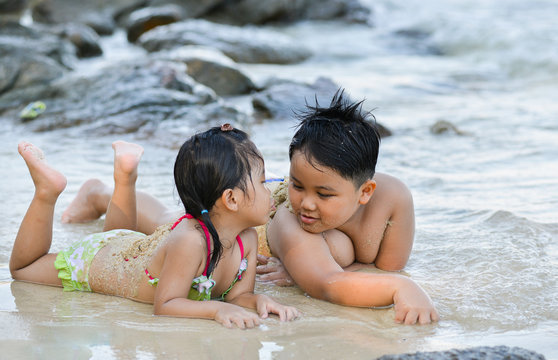 cute litte boy and girl talk on the beach