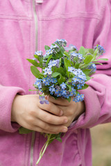 bukiet wiosennych leśnych kwiatów w dłoni dziecka