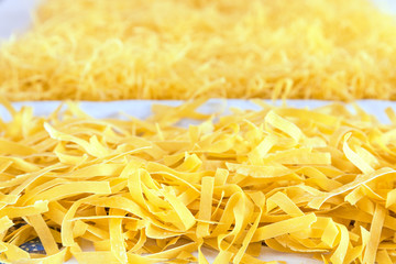 Raw pasta strewn on table for drying