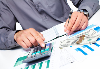 Hand with calculator and money.