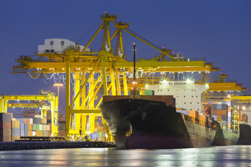 Gantry crane loading and unloading cargo container  from cargo ship at port to show global...