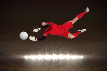 Composite image of fit goal keeper jumping up