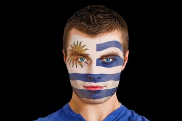 Composite image of serious young uruguay fan with facepaint