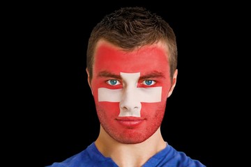 Composite image of serious young swiss fan with facepaint