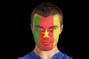 Composite image of serious young cameroon fan with facepaint