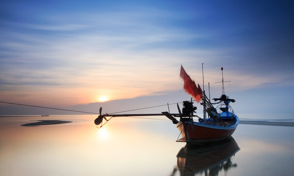 Longtail boat in the sunrise over sea and blue sky background