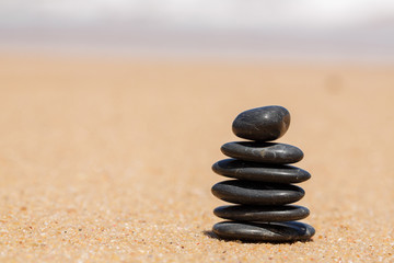 Fototapeta na wymiar Zen stones jy on the sandy beach near the sea.