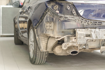 Car without a fender in repair shop.