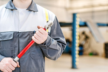 Mechanic with torque wrench at auto repair shop. - obrazy, fototapety, plakaty