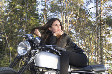 Fototapeta na wymiar Sexy female woman on a motorcycle posing in a forest