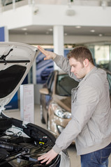 Man examining new car at the dealership.