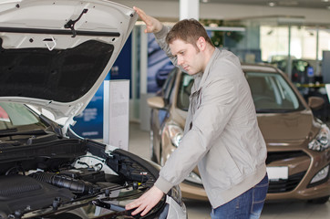 Man examining new car at the dealership.