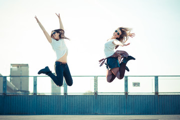 two beautiful young women jumping and dancing