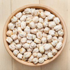 Chickpeas in wooden bowl, on wooden kitchen table