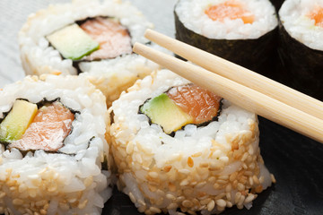 sushi rolls on black wooden plate