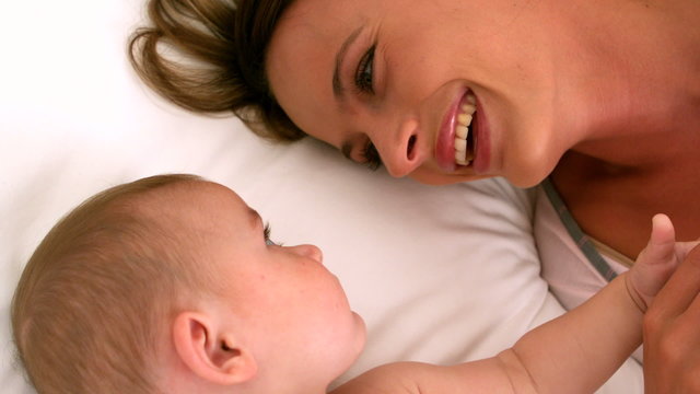 Cute baby on a bed with mother