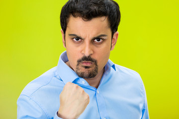 Portrait angry man with fist up, isolated green background 