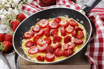 Strawberry omelette on frying pan