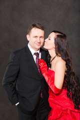 Portrait of happy couple in love posing at studio on gray