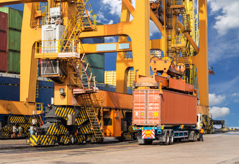 Quay crane loading container from container ship to container tr