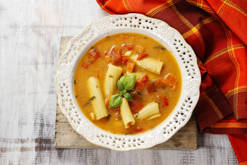 Vegetable soup in ceramic plate standing on wooden table