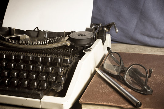 Typewriter with antique book and eyeglasses,