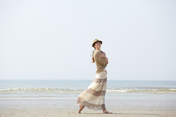 Fototapeta na wymiar Woman smiling and walking on the beach