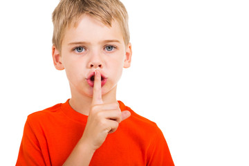 little boy doing silence gesture