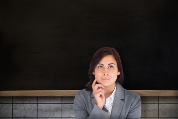 Composite image of smiling thoughtful businesswoman