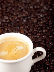 Fresh cup of dark roasted coffee with coffeebeans