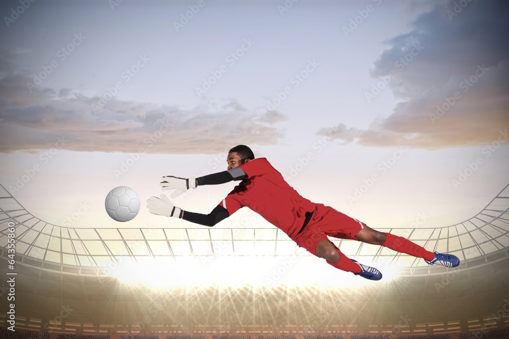 Fototapete composite image of goalkeeper in red making a save