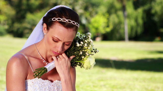 Upset bride sitting on the grass