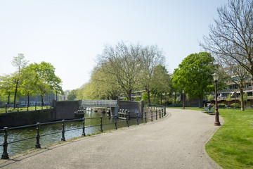 Typical Dutch canal landscape with water, trees,  grass and boat