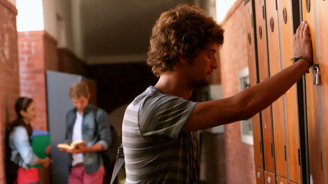 Overwhelmed student leaning against locker