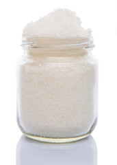 White refine sugar in a glass container over white background